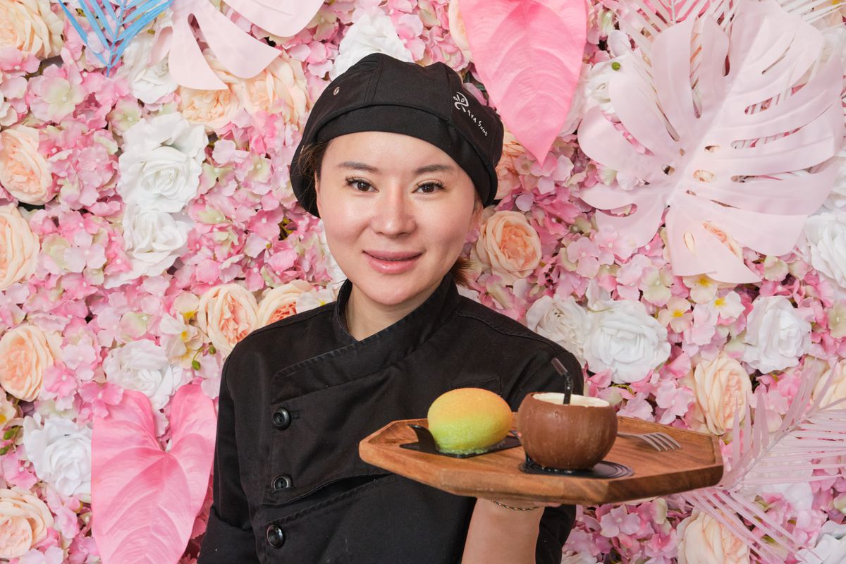 Qi Guan holds a platter of dessert