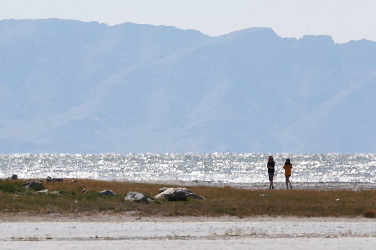 Two women walk on the beach near Saltair on the Great Salt Lake on Sunday, April 12, 2020.