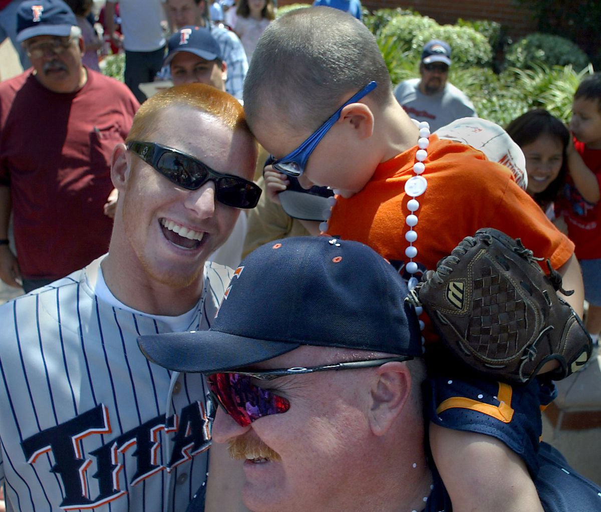 Cal State Fullerton baseball player Justin Turner, left, pals around by rubbing heads with little ba