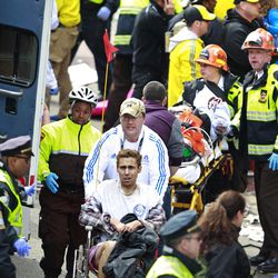 Medical workers aid injured people at the finish line of the 2013 Boston Marathon following an explosion in Boston, Monday, April 15, 2013. Two explosions near the finish of the Boston Marathon on Monday, killing at least  three people, injuring over 20 others.