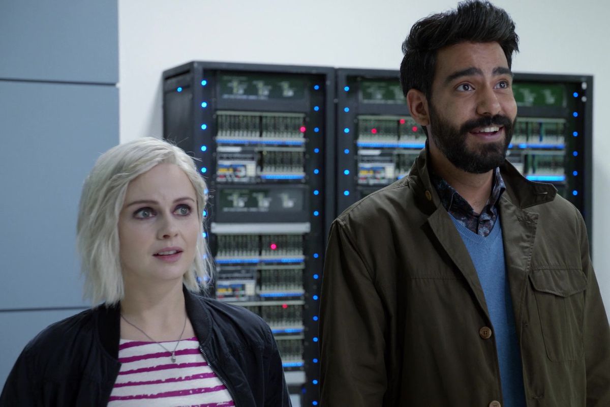Dr. Olivia “Liv” Moore (Rose McIver) stands next to a taller man with a black hair and beard. They are both awkwardly smiling.