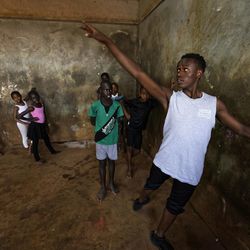 In this photo taken Friday, Dec. 9, 2016, young ballerinas receive instruction from Kenyan ballet dancer Joel Kioko, 16, right, in a room at a school in the Kibera slum of Nairobi, Kenya. In a country not usually associated with classical ballet, Kenya's most promising young ballet dancer Joel Kioko has come home for Christmas from his training in the United States, to dance a solo in The Nutcracker and teach holiday classes to aspiring dancers in Kibera, the Kenyan capital's largest slum. 