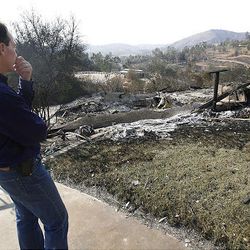 Poway California Stake President Gary Sabin stands and surveys the burned remains of one of his neighbors homes that was burned in the California fires.
