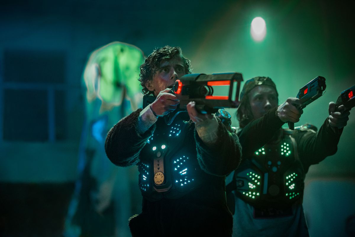 The stars of Blasted hold laser tag guns and wear laser tag vests.