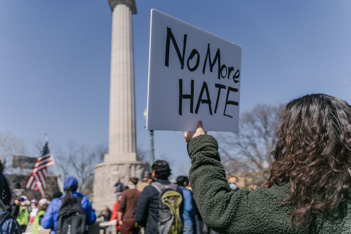 Li Liu, 48, raises a sign during the Stop Asian Hate March at the Illinois Centennial Monument in Logan Square, Saturday afternoon, March 20, 2021.