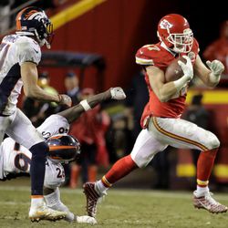Kansas City Chiefs tight end Travis Kelce (87) carries the ball away from Denver Broncos safety Darian Stewart (26) and safety Justin Simmons (31) during the second half of an NFL football game in Kansas City, Mo., Sunday, Dec. 25, 2016. 