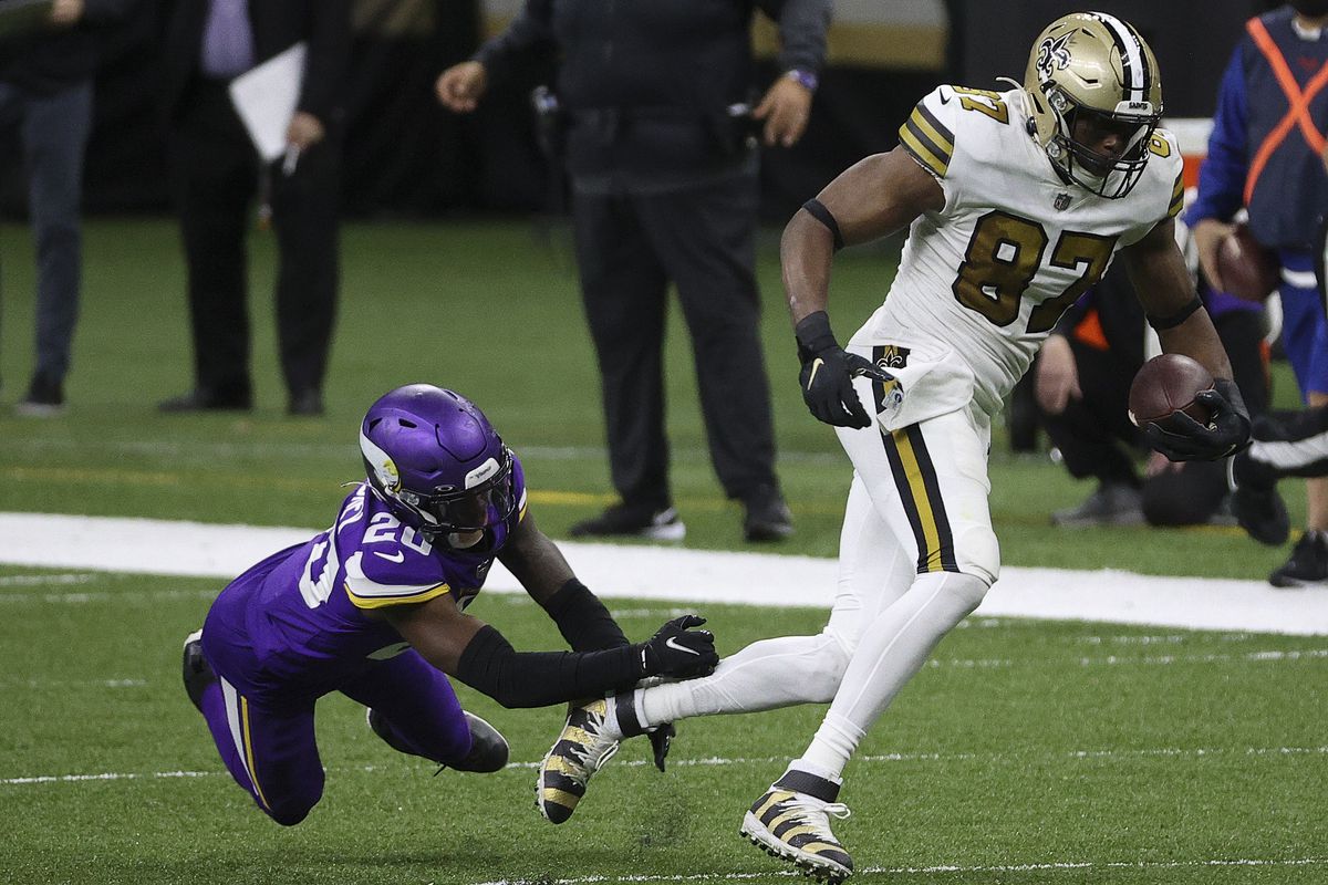 Jared Cook #87 of the New Orleans Saints makes a reception past Jeff Gladney #20 of the Minnesota Vikings at Mercedes-Benz Superdome on December 25, 2020 in New Orleans, Louisiana.