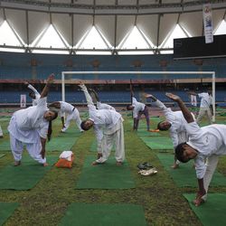 In this Sunday, June 14, 2015, photo,  Indians perform yoga in a stadium in New Delhi, India. Yoga has a long history India, reaching back for thousands of years. There are no reliable estimates of how many people regularly practice yoga in India, though the number is certainly in the millions. 
