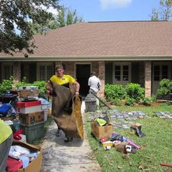 Elder Zachary Dustin carries carpet from a flooded home in LaPlace, La.
