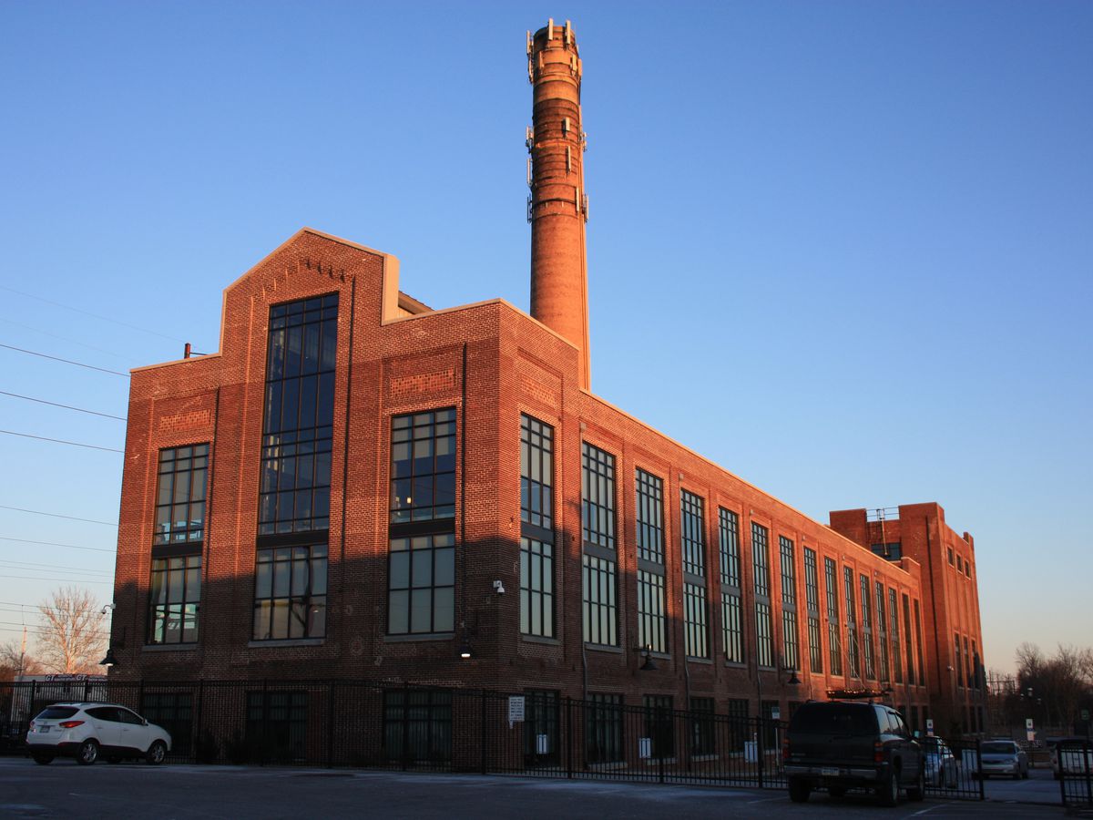 A large red brick building in Ambler, Pennsylvania. There is a giant smoke stack on the building.