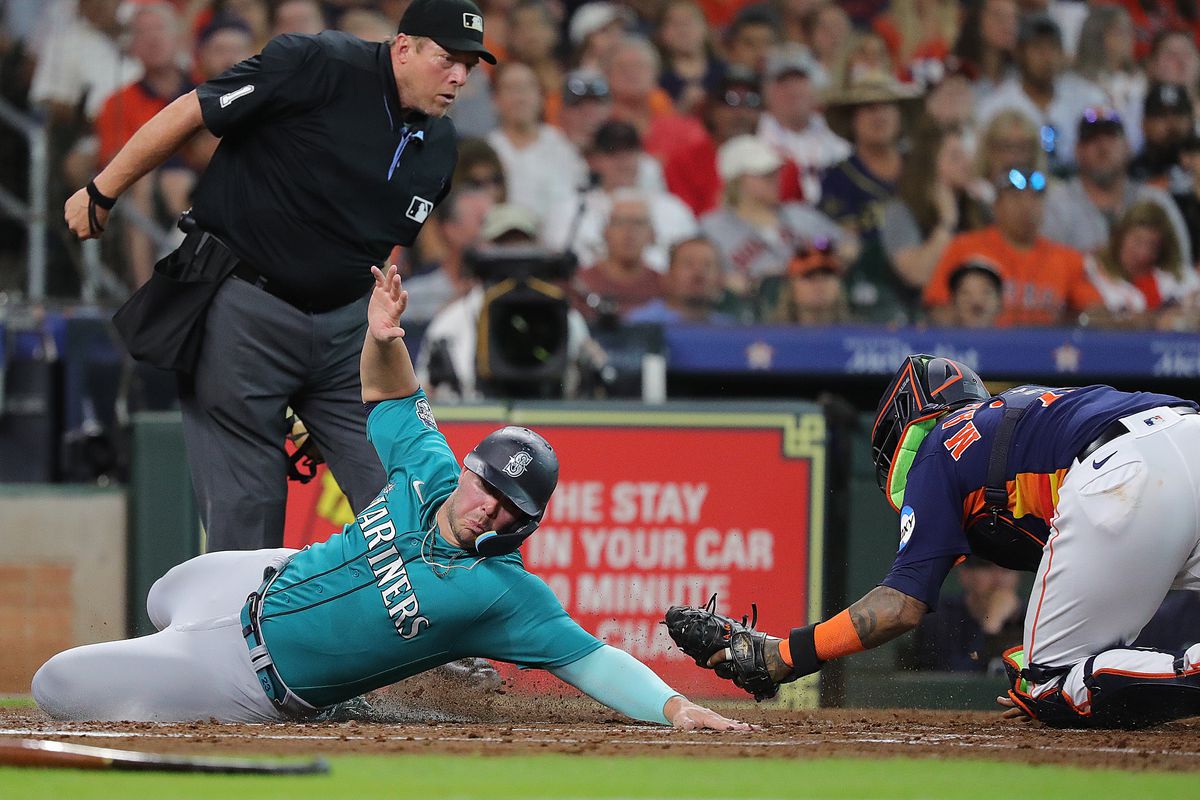 Ty France #23 of the Seattle Mariners scores in the third inning on a double by Teoscar Hernandez as Martin Maldonado #15 of the Houston Astros can’t handle the throw at Minute Maid Park on August 19, 2023 in Houston, Texas.