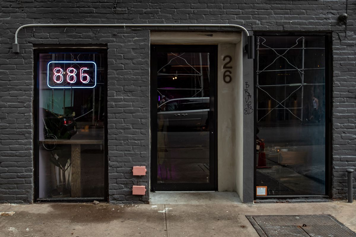 The exterior of Taiwanese restaurant 886 with a glass door, window, and the numbers 886 on the front
