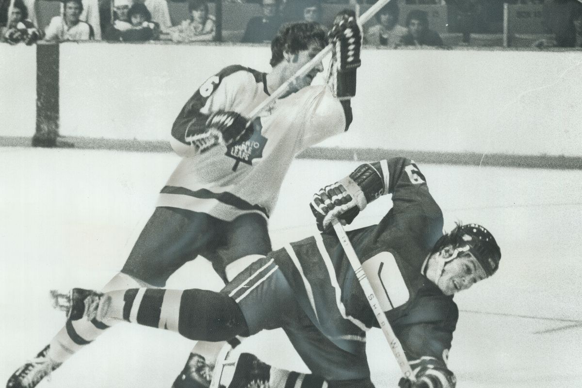 Caught In The Act: Maple Leafs’ Rod Seiling (16) scoops the feet from under Vancouver Cannucks’ Don