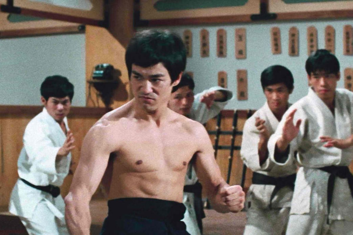 a shirtless Bruce Lee is ready for a fight in Fist of Fury