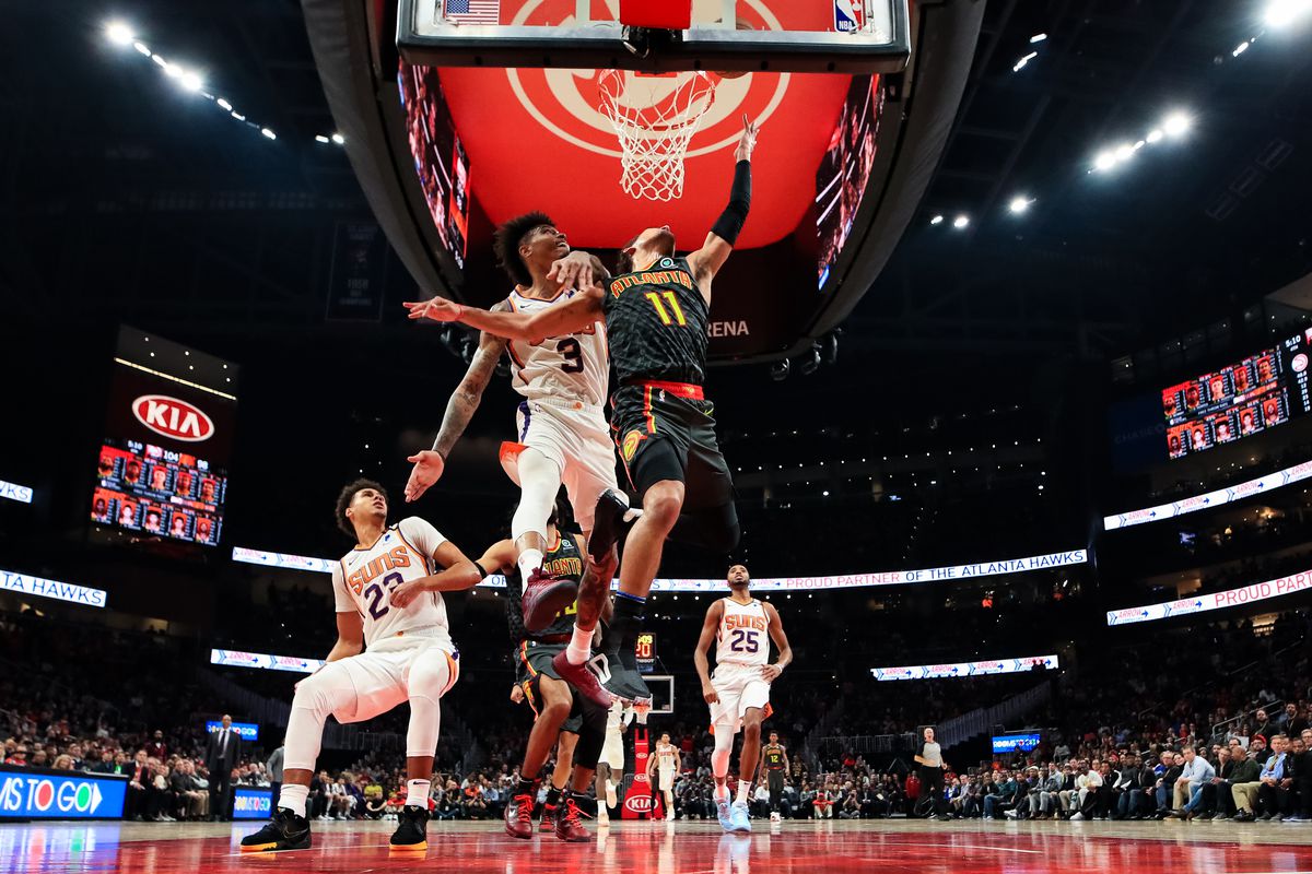 Trae Young of the Atlanta Hawks goes up for a basket against Kelly Oubre Jr. of the Phoenix Suns at State Farm Arena on January 14, 2020 in Atlanta, Georgia.
