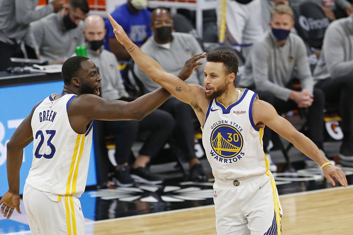 Stephen Curry of the Golden State Warriors celebrates with Draymond Green after hitting a three pointer against the San Antonio Spurs in the second half at AT&amp;T Center on February 9, 2021 in San Antonio, Texas.