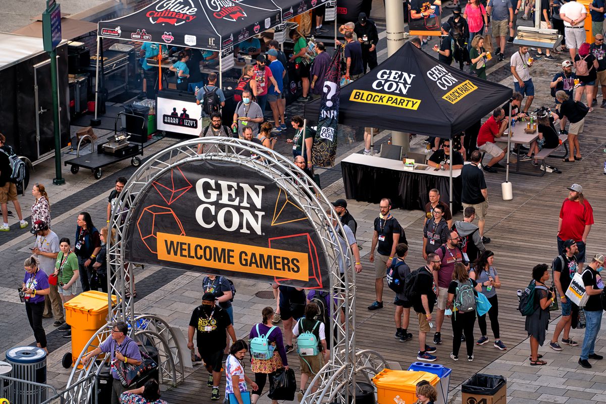 A view of the food trucks at Gen Con. An arch holds a banner that reads “Welcome Gamers!”