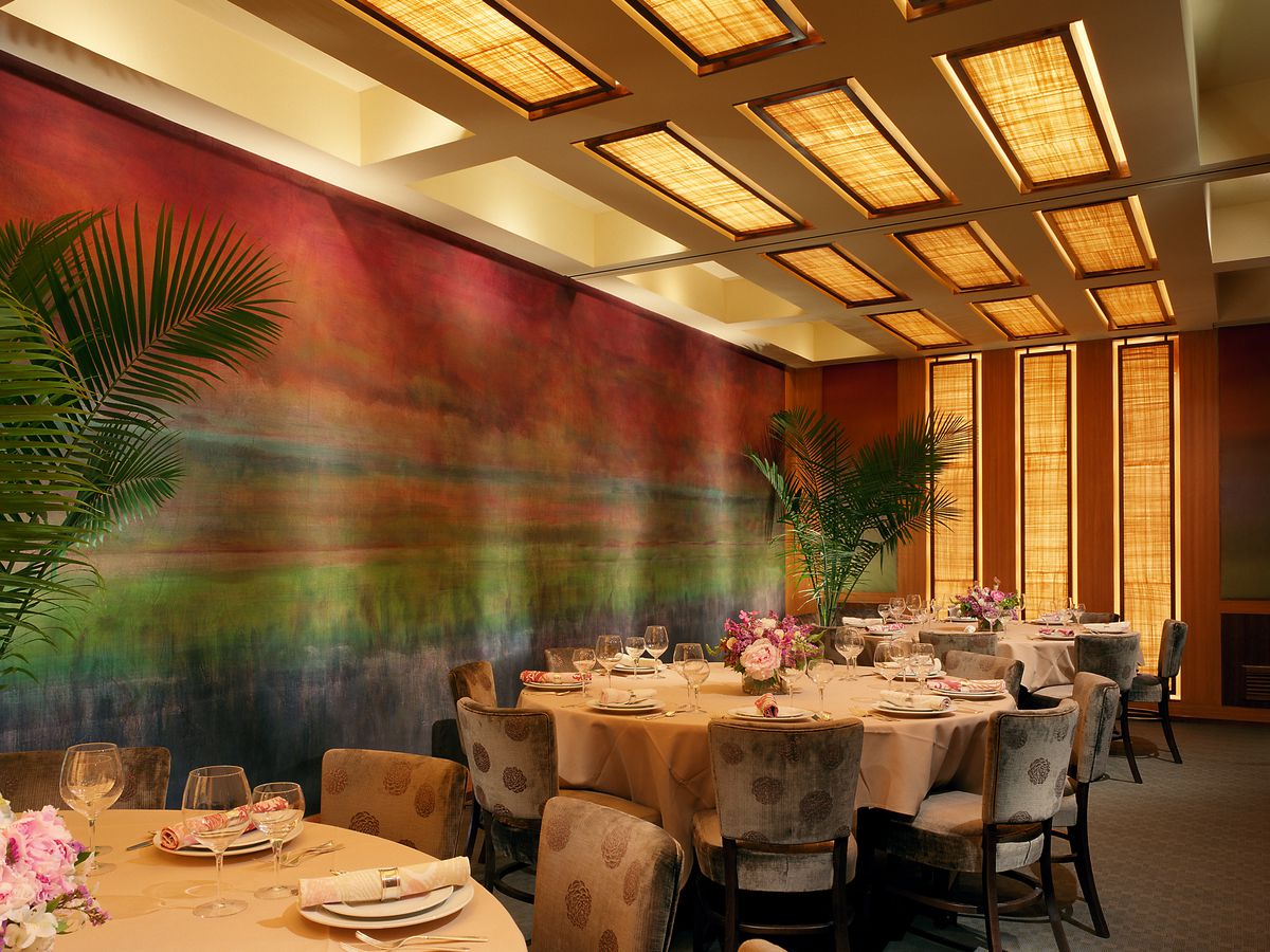 dining room with two round tables and a colorful painted wall