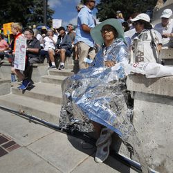 Rachel Olivarez-Sellers of Denver dons a thermal blanket during an immigration rally and protest in Civic Center Park Saturday, June 30, 2018, in downtown Denver. (AP Photo/David Zalubowski)