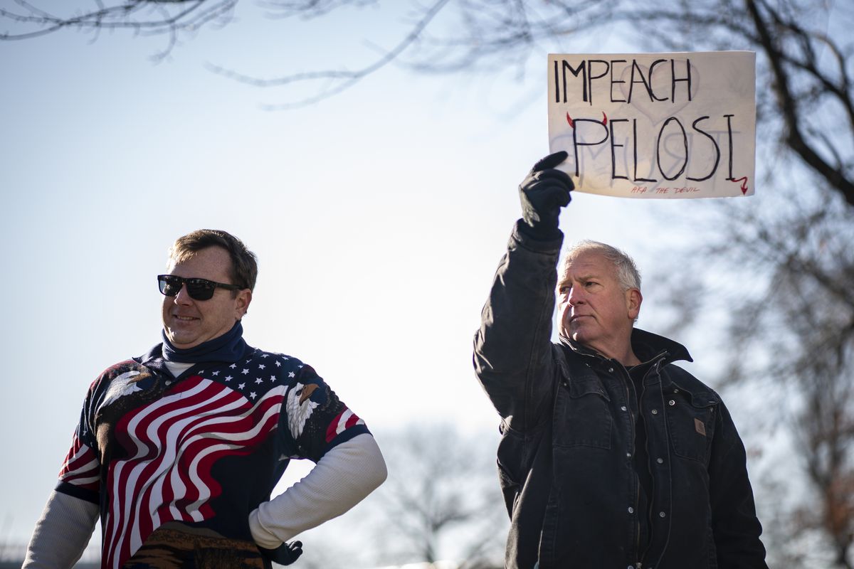 A man with a “Impeach Pelosi” sign