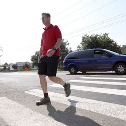 West Valley police detective Thomas Sanford crosses a school zone crosswalk as traffic drives past during a crosswalk safety operation in West Valley City on Tuesday, Aug. 7, 2018. Traffic must stop and wait for pedestrians in a school zone crosswalk to get from curb to curb before proceeding. This is different from other crosswalks, where motorists have to wait for pedestrians to get to the other half of the road before proceeding.