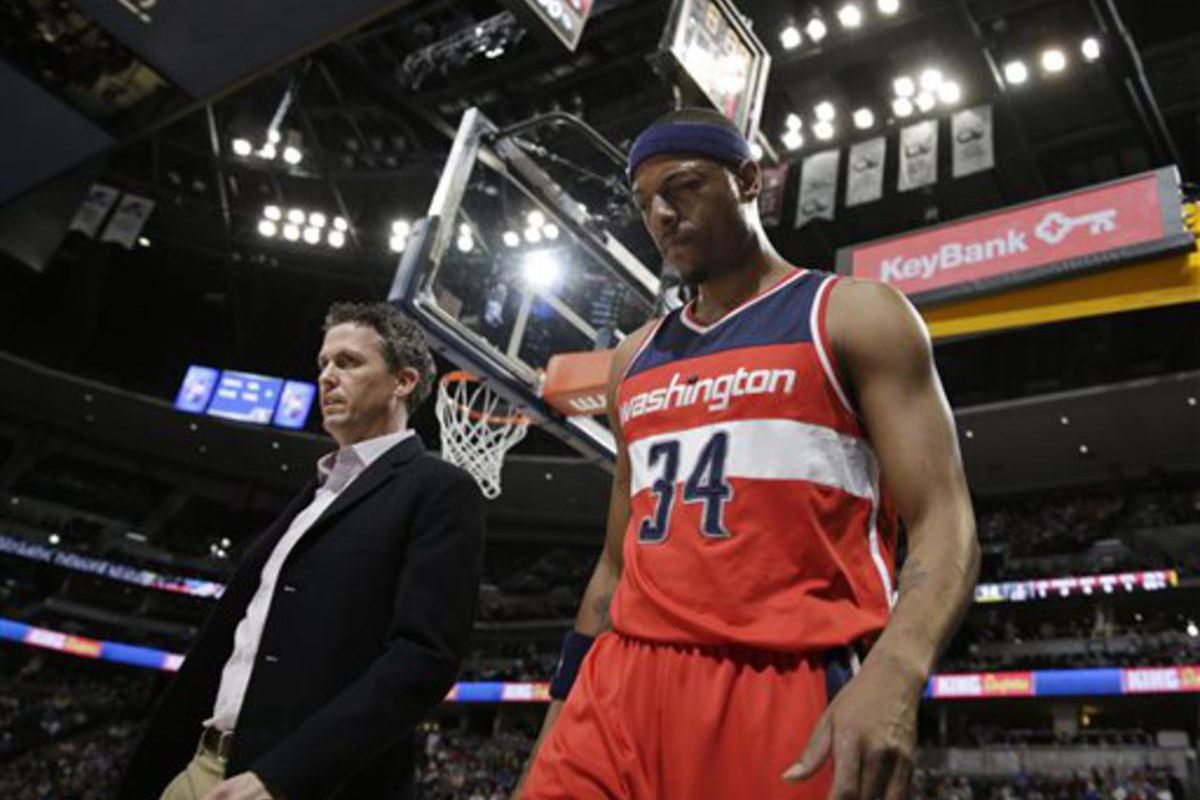 Head trainer Eric Waters, left, walks with Washington Wizards forward Paul Pierce to the lockerroom after getting hit in the left eye while facing the Denver Nuggets in the first quarter of an NBA basketball game Sunday, Jan. 25, 2015, in Denver.