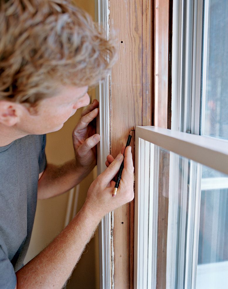 Person marking the side of the window to prepare to cut the side beads.
