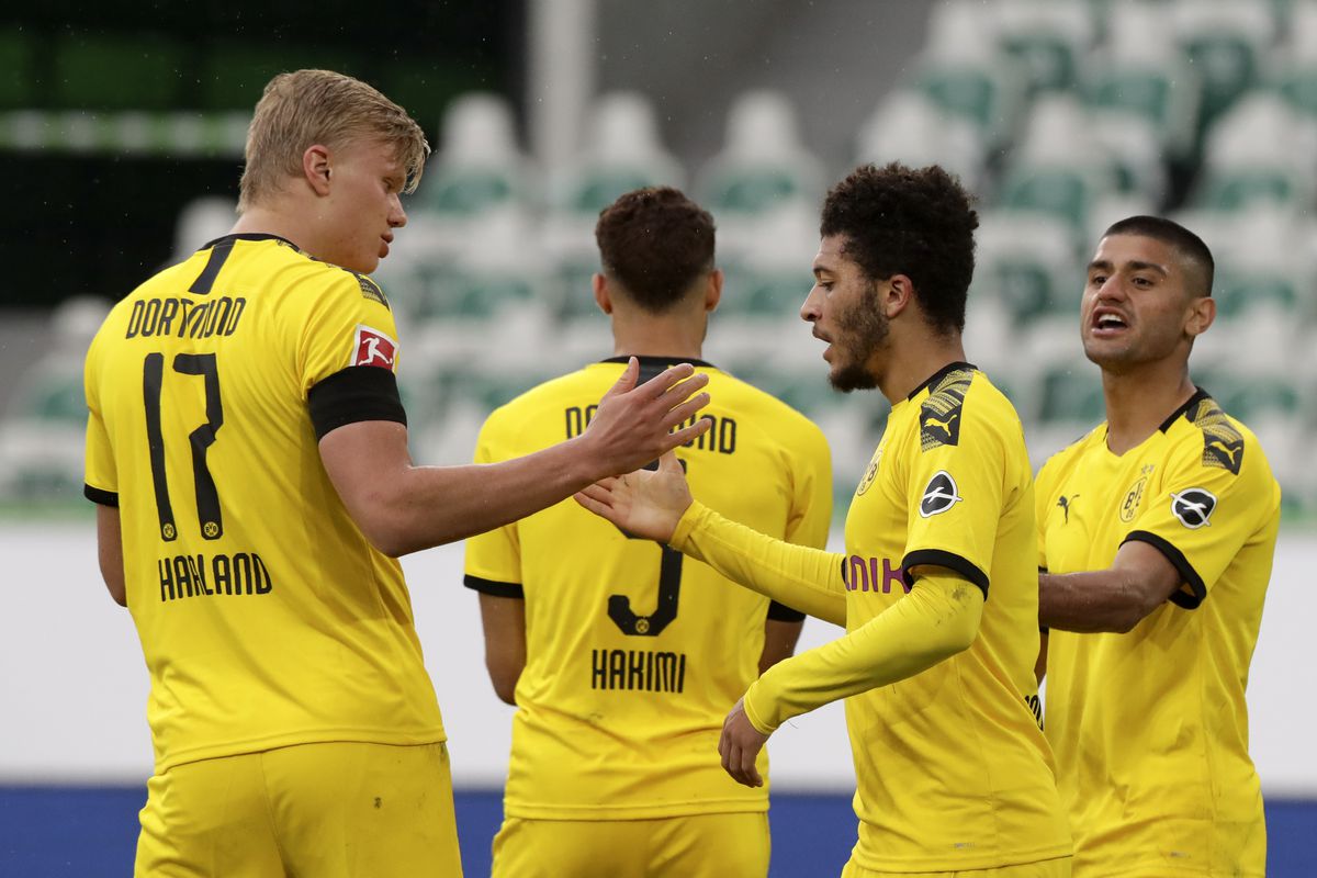 Jadon Sancho of Borussia Dortmund celebrates with Erling Haaland after Achraf Hakimi (Obscured) scored their side’s second goal during the Bundesliga match between VfL Wolfsburg and Borussia Dortmund at Volkswagen Arena on May 23, 2020 in Wolfsburg, Germany.
