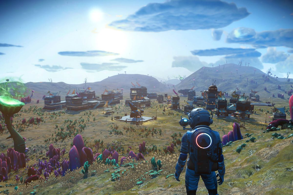 an explorer in a space suit looks out over a vast alien wilderness in No Man’s Sky