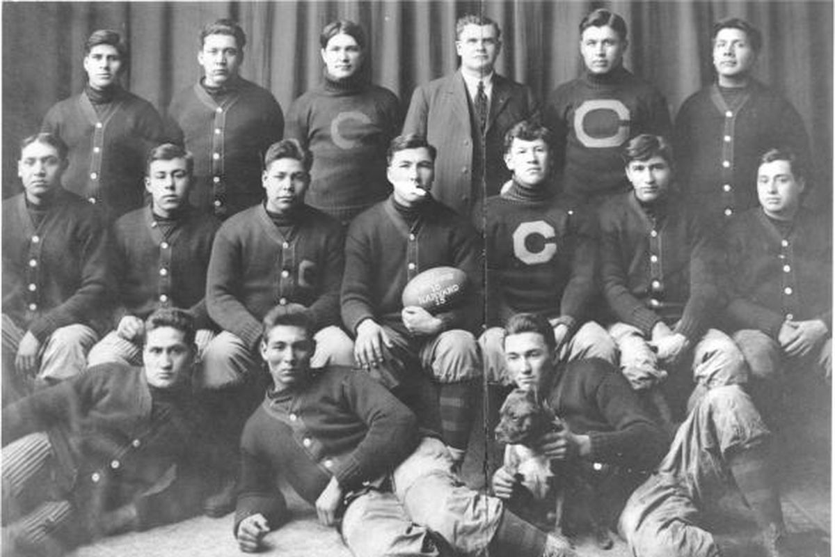 The 1911 Carlisle Indians posing with the game ball after they upset Harvard