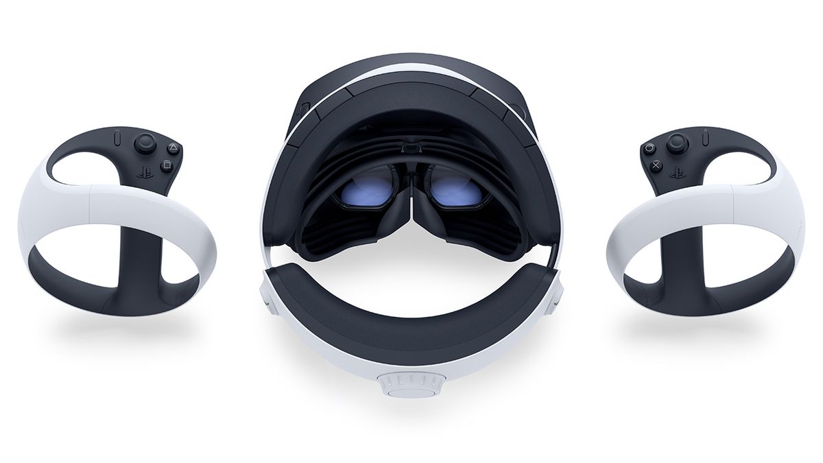The PSVR 2 headset, as seen from above, resting on a white surface, flanked by both VR2 Sense controllers