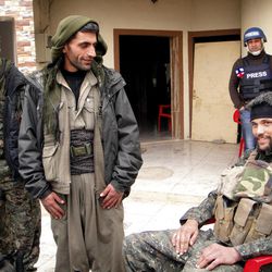 In this Thursday, Jan. 29, 2015 photo, Jordan Matson, 28, right, a former U.S. Army soldier from Sturtevant, Wis., takes a break with other fighters from the main Kurdish militia, the People's Protection Units, or YPG, in Sinjar, Iraq. Matson and dozens of other Westerners now fight with the Kurds, spurred on by Kurdish social media campaigners and a sense of duty many feel after Iraq, the target of a decade-long U.S.-led military campaign, collapsed under an Islamic State group offensive within days last summer. 