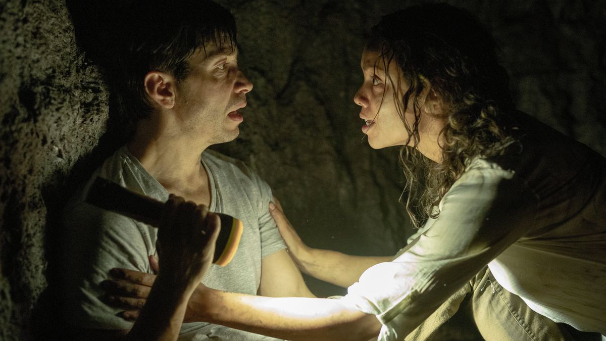 Justin Long and Georgina Campbell as AJ and Tess trapped in a basement maze holding a flashlight in Barbarian