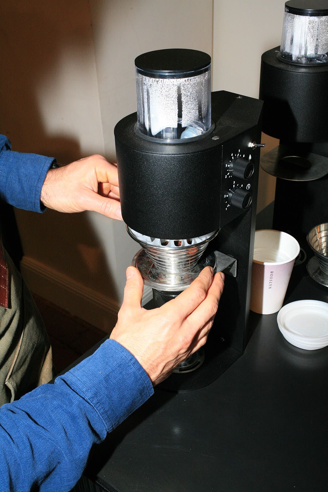 The dripper full of ground coffee is placed under a Marco SP9 brewer
