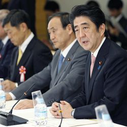 Japanese Prime Minister Shinzo Abe speaks at a meeting with a panel of experts at his official residence in Tokyo, Wednesday, Feb. 25, 2015. The panel of experts appointed by Abe met for the first time Wednesday to discuss what he should say in a statement marking the 70th anniversary of the end of World War II, fueling speculation that he may water down previous government apologies for the country's wartime past. Second from right is government spokesman Chief Cabinet Secretary Yoshihide Suga. 