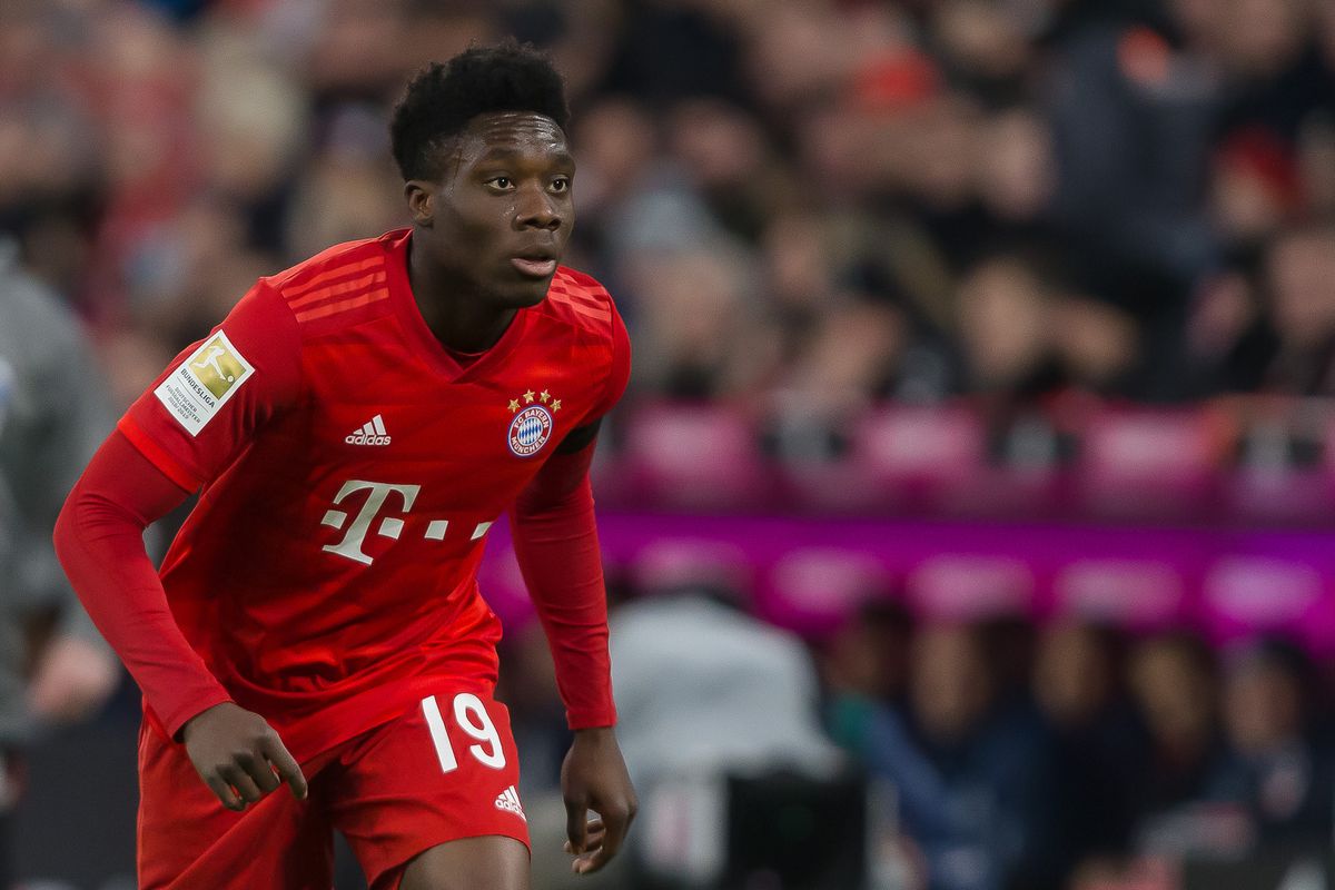 Alphonso Davies running in a crouched position for Bayern Munich. 