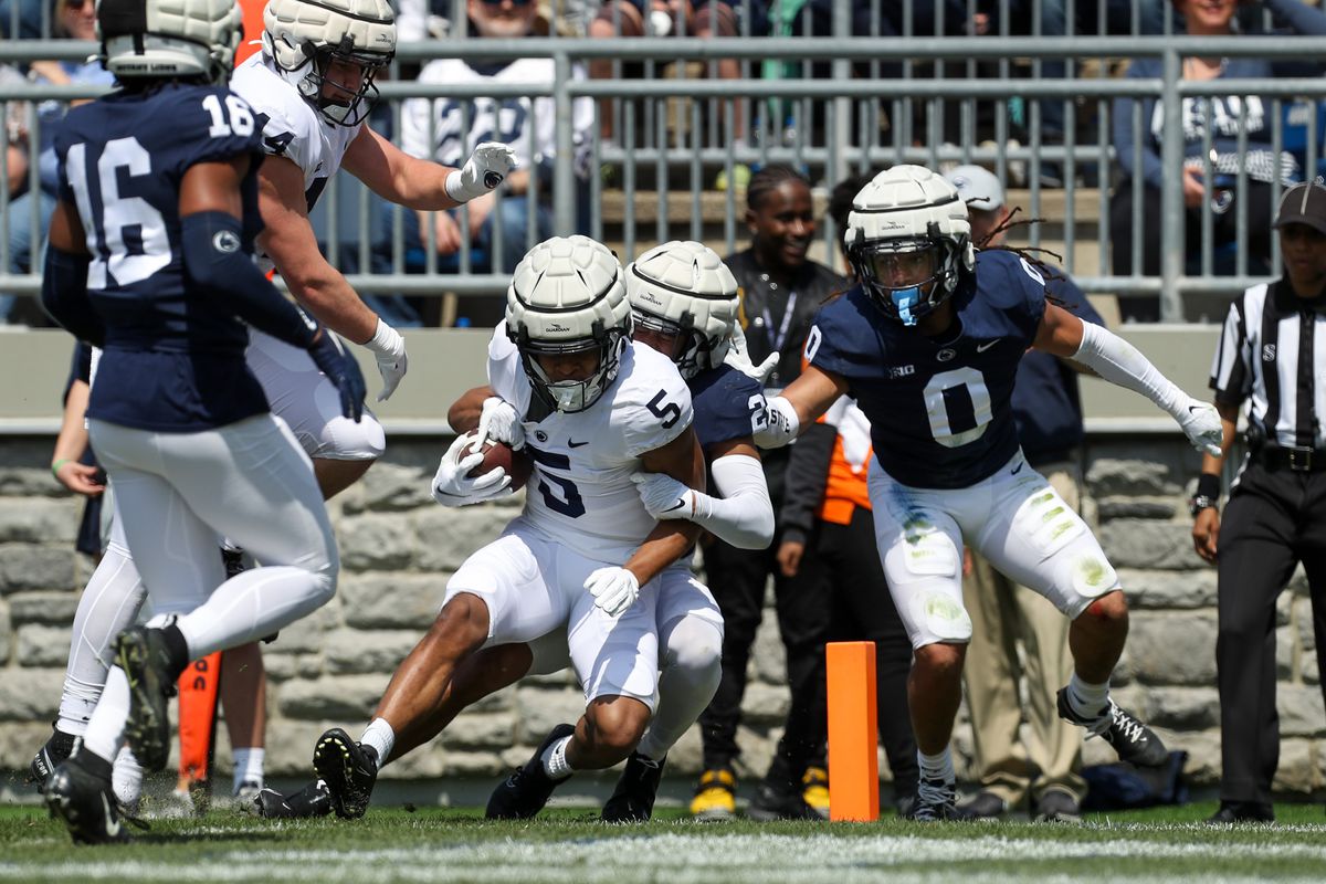 Penn State Nittany Lions wide receiver Mitchell Tinsley (5) is tackled short of the goal line by safety Keaton Ellis (2) during the Blue White spring game at Beaver Stadium. The defense defeated the offense 17-13.