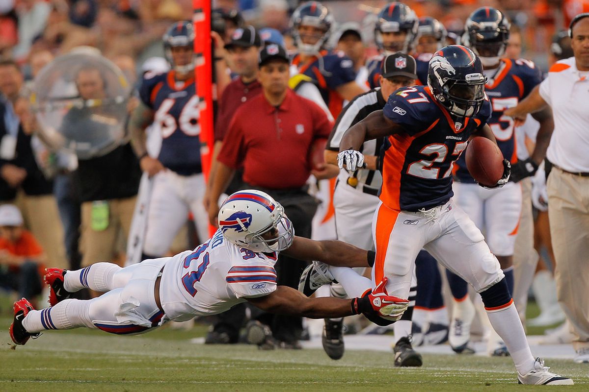 DENVER, CO - AUGUST 20:  Running back Knowshon Moreno #27 of the Denver Broncos is tripped up by a diving safety Jairus Byrd #31 of the Buffalo Bills. (Photo by Justin Edmonds/Getty Images)