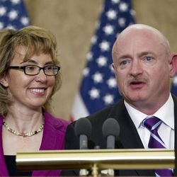 Former Arizona Rep. Gabrielle Giffords listens as her husband, retired astronaut Mark Kelly speaks on Capitol Hill, in Washington, Tuesday,  April 16, 2013, during a ceremony to honor Gabriel "Gabe" Zimmerman.  Zimmerman was Giffords' outreach director until he was killed in the January 2011 shooting rampage in Tucson where Giffords was wounded.  (AP Photo/Jose Luis Magana)