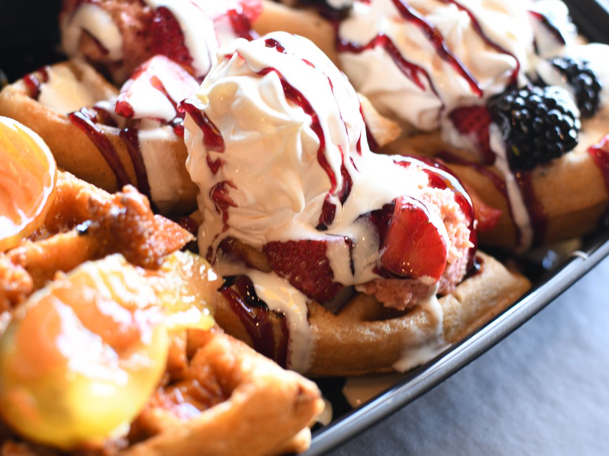 A flight of mini waffles topped with berries and fruit and cream from Waffle Cafe in Detroit, Michigan.