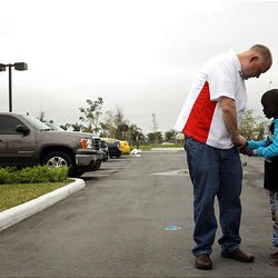Eric Evans of Eden, Utah, talks with his newly adopted Haitian son, Jean Tony, at their hotel in Miami, Fla., on Sunday. 