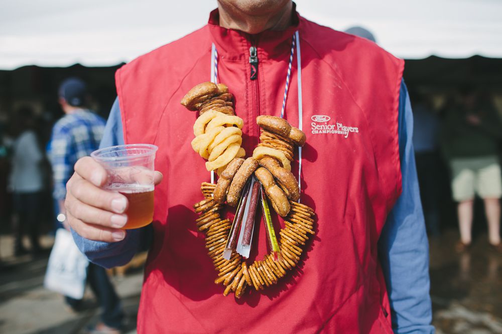 A person wears a pretzel necklace and a plastic cup of light beer at Michigan Brewers Guild festival in 2014.