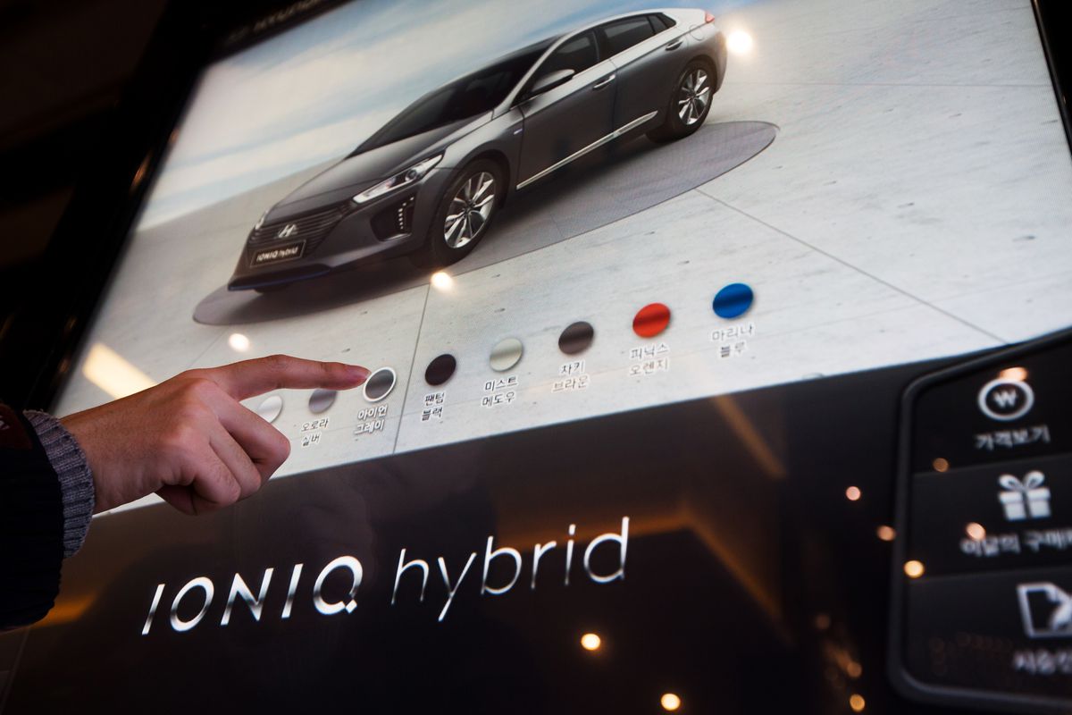 A visitor uses a touchscreen panel showing a Hyundai Motor Company Ioniq hybrid sedan at a company dealership in the Gangnam district of Seoul, South Korea.