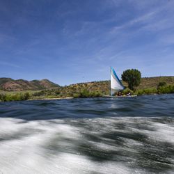 A boat controlled by Derek Sunquist sails on East Canyon Reservoir in East Canyon State Park on Thursday, July 18, 2019. The sailboat is equipped with technology that allows Sundquist, a quadriplegic, to control the speed and direction of the craft with blows and sucks through a straw.