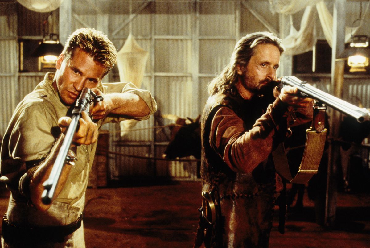 Val Kilmer and Michael Douglas aim shotguns offscreen in The Ghost and the Darkness