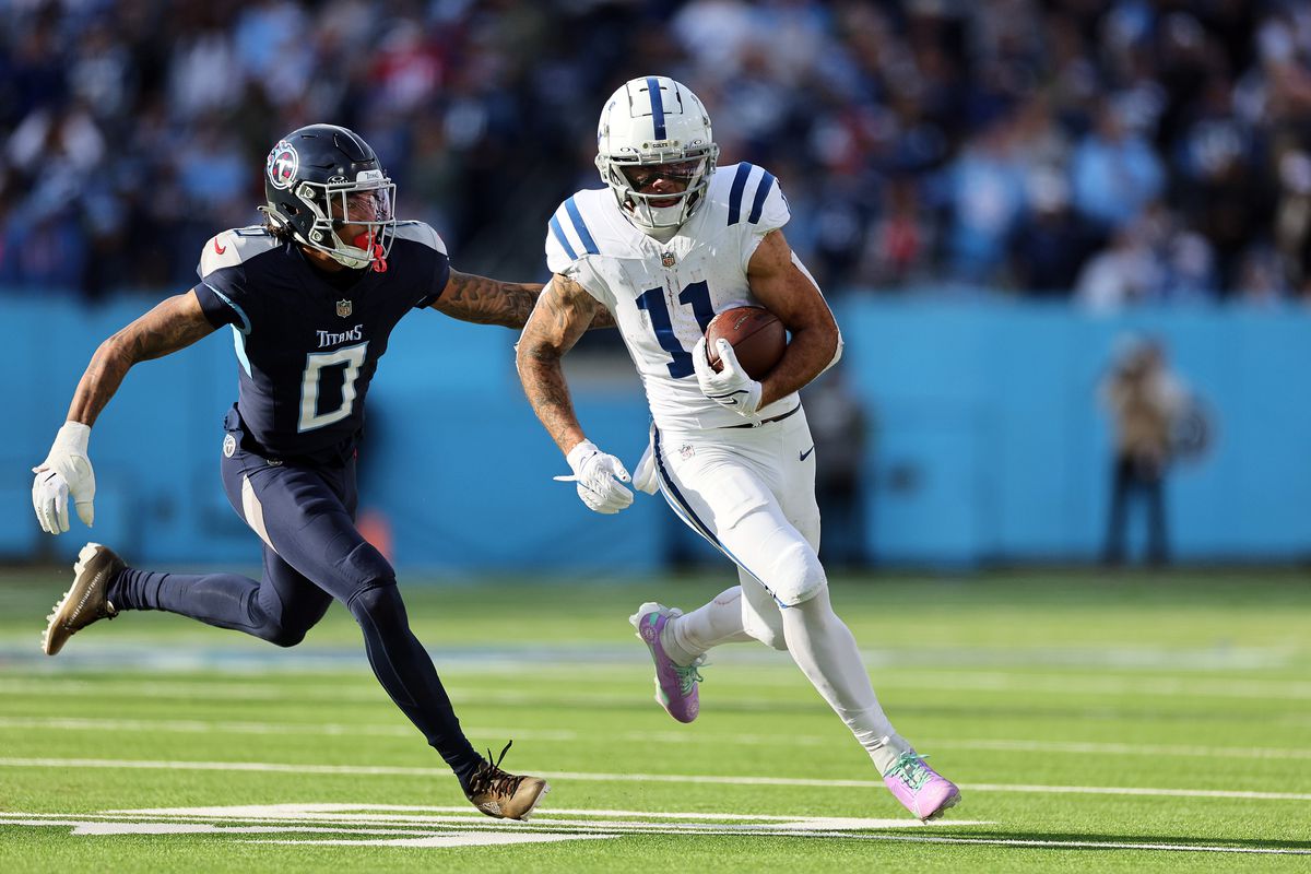 Michael Pittman Jr. #11 of the Indianapolis Colts carries the ball past Sean Murphy-Bunting #0 of the Tennessee Titans during the second half at Nissan Stadium on December 03, 2023 in Nashville, Tennessee.