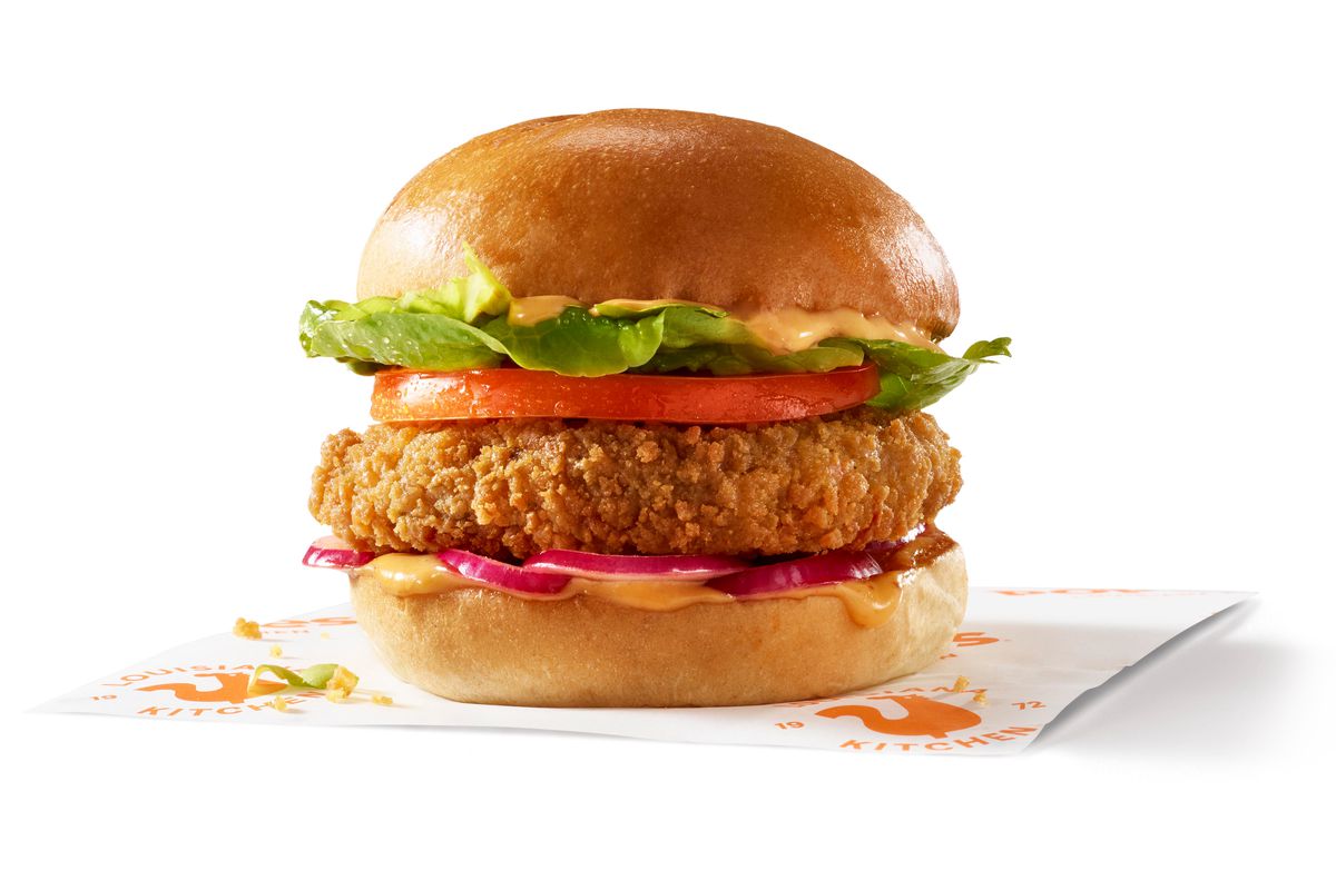A breaded red bean patty with lettuce, tomato, and Creole sauce, in a bun.