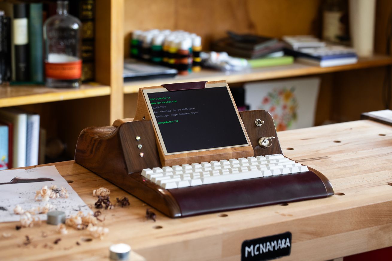 A photo of a computer made of wood, on a table.