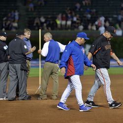 Umpires, Cubs VP of stadium ops Carl Rice (blue shirt), head groundskeeper Roger Baird (blue/white shirt), and the two managers