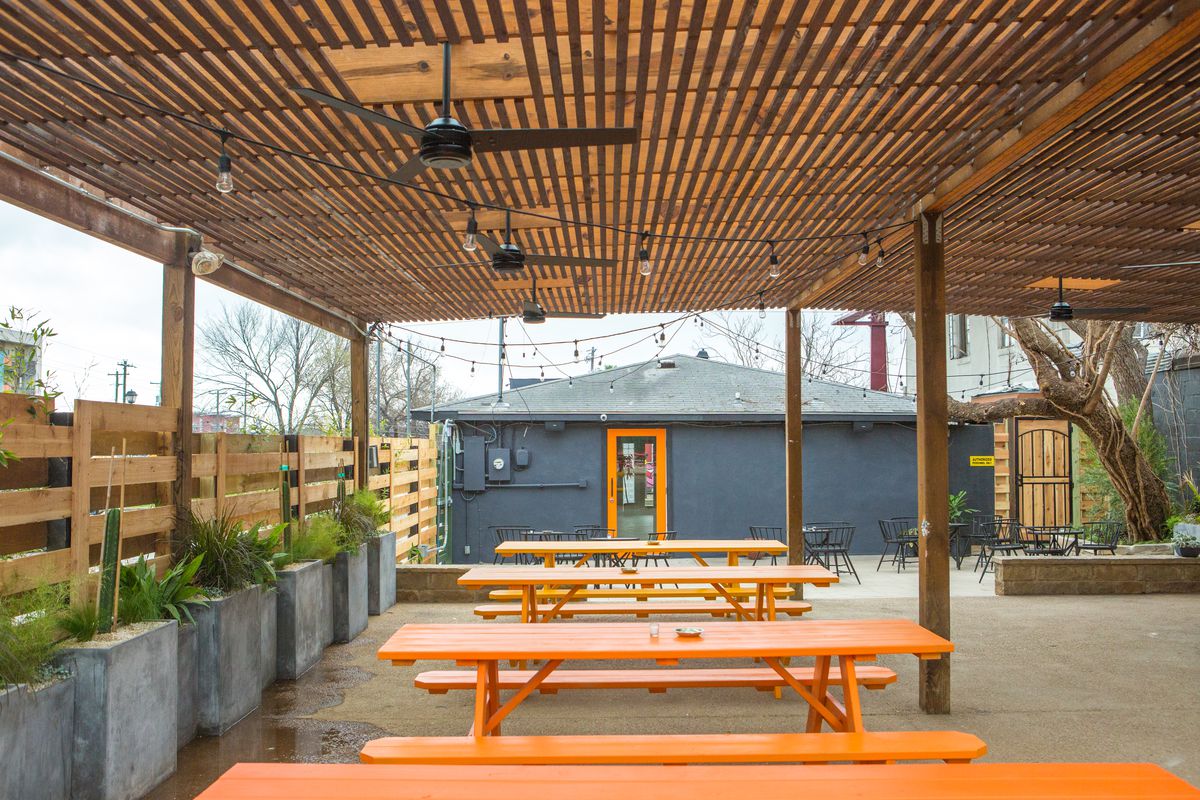 An outdoor patio with orange picnic tables